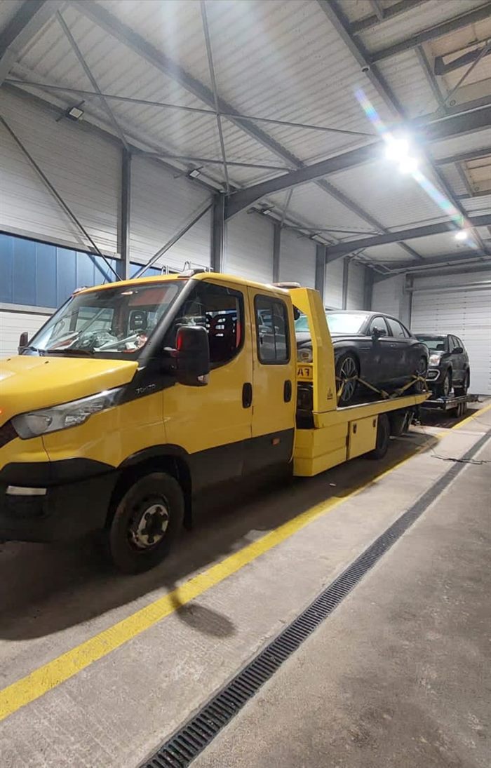 Yellow vehicle recovery truck inside a workshop